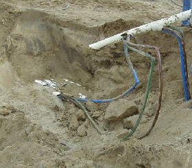 Broken conduits and damaged underground cables in trench