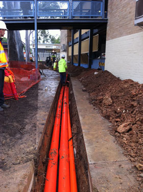 Elam workers installing underground cables and conduits in trench